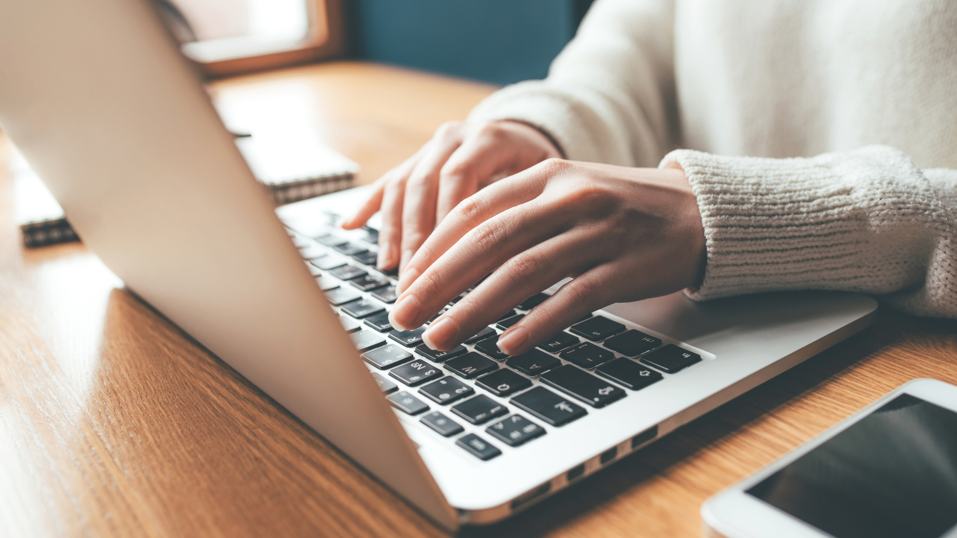 femme qui tape sur le clavier de son ordinateur portable